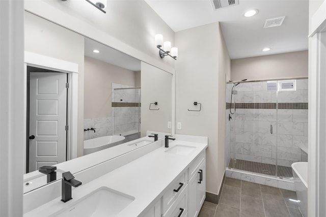 bathroom with visible vents, a sink, and a shower stall