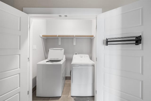 laundry area with laundry area, light tile patterned flooring, and washing machine and clothes dryer