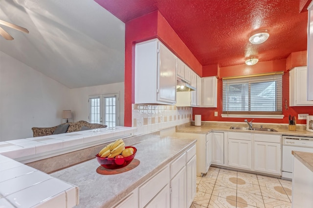 kitchen with white cabinets, a sink, dishwasher, and light tile patterned floors