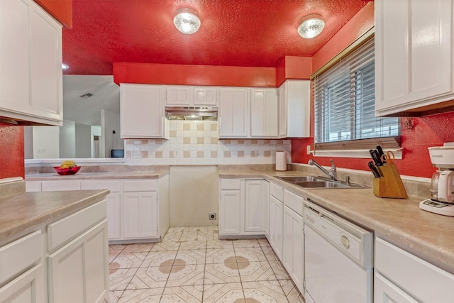 kitchen featuring tasteful backsplash, dishwasher, light countertops, white cabinetry, and a sink