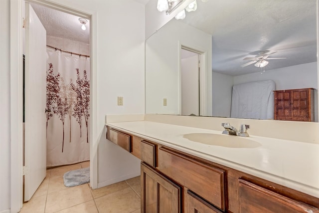 full bathroom featuring a textured ceiling, tile patterned flooring, vanity, and a ceiling fan