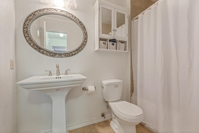 bathroom with tile patterned flooring, baseboards, toilet, and curtained shower