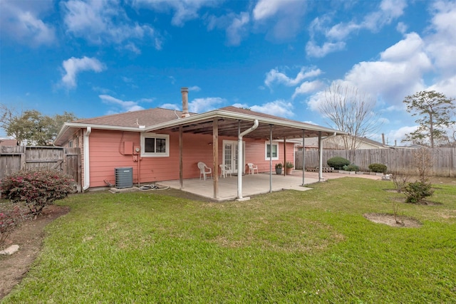 back of house featuring central AC, a patio area, a lawn, and a fenced backyard