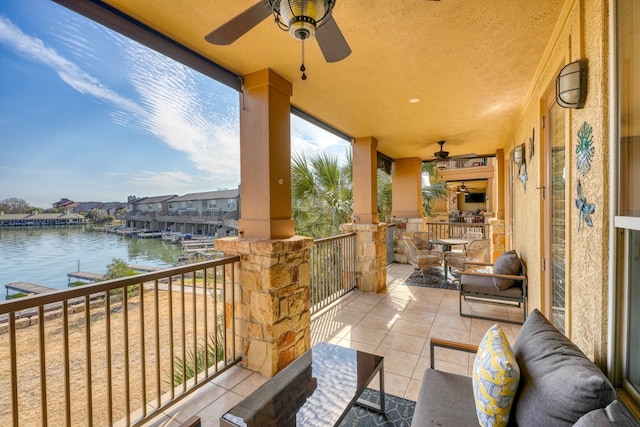 balcony featuring a ceiling fan and a water view