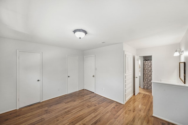 unfurnished bedroom featuring wood finished floors and baseboards