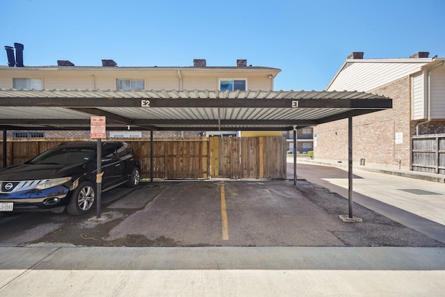 covered parking lot featuring fence