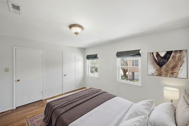 bedroom featuring visible vents and wood finished floors