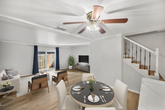 dining space with baseboards, visible vents, stairway, and wood finished floors