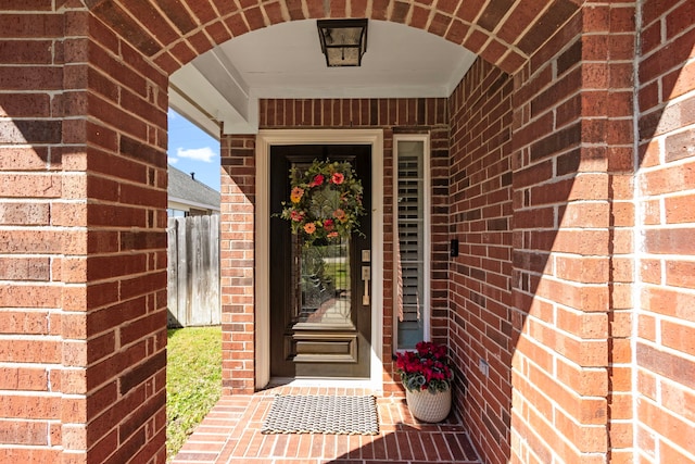 entrance to property with fence and brick siding