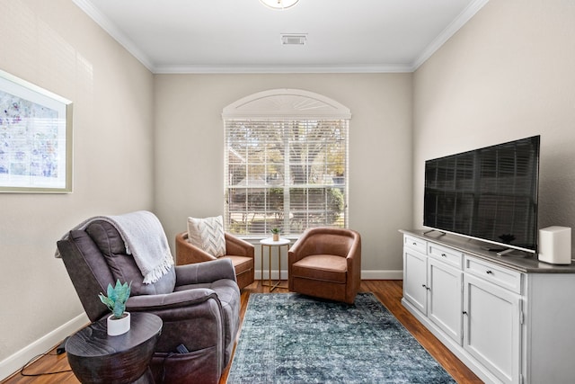 living area with baseboards, wood finished floors, and crown molding