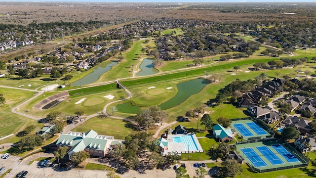 birds eye view of property with view of golf course and a water view