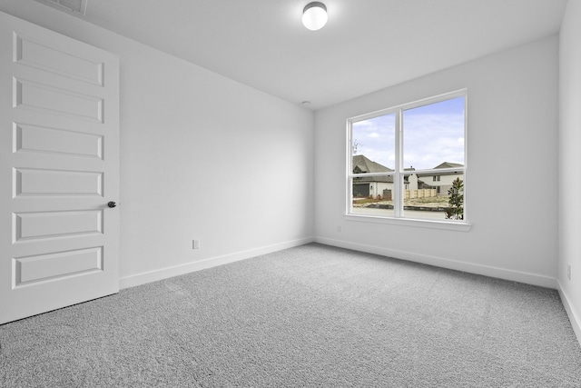 unfurnished room with carpet flooring, visible vents, and baseboards