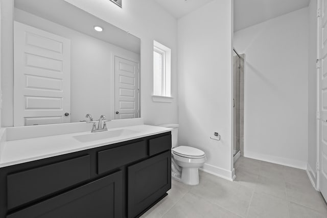 bathroom featuring tile patterned flooring, toilet, vanity, baseboards, and a stall shower