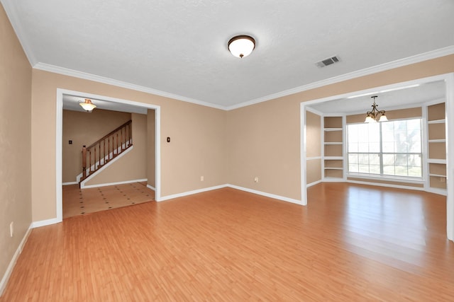 empty room with stairs, baseboards, visible vents, and light wood-style floors