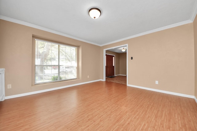 unfurnished room featuring ornamental molding, wood finished floors, and baseboards