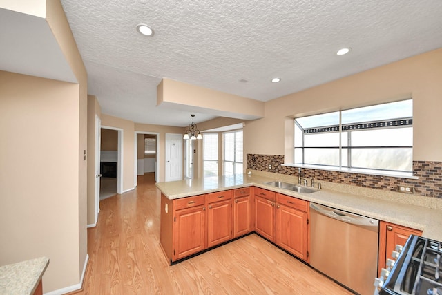 kitchen with a sink, light wood-type flooring, range, dishwasher, and tasteful backsplash