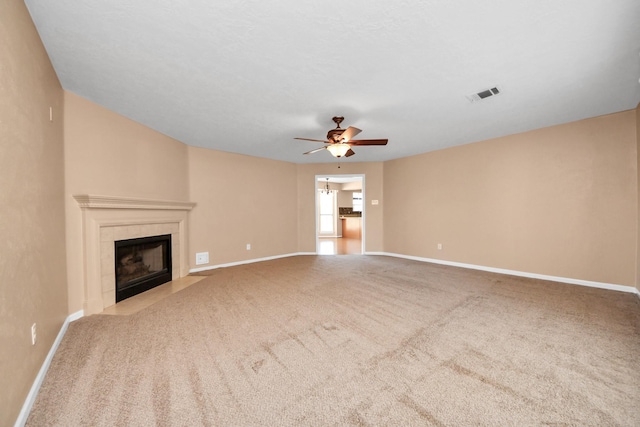 unfurnished living room with carpet, a tile fireplace, visible vents, and baseboards