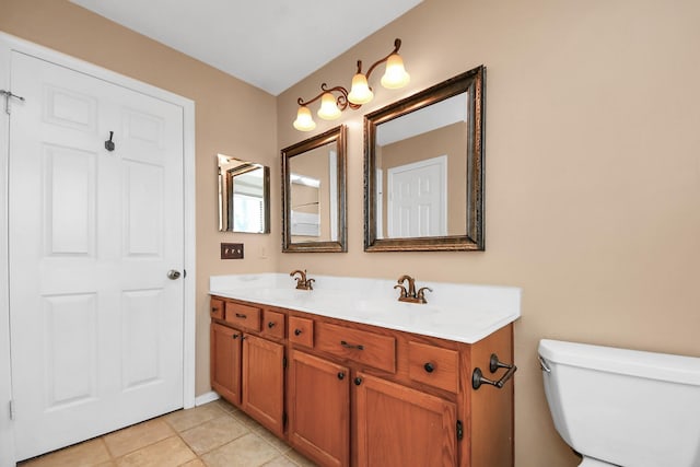 bathroom featuring double vanity, tile patterned flooring, a sink, and toilet