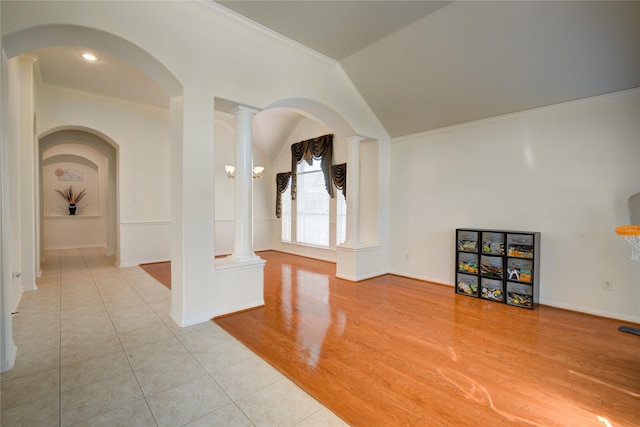 spare room with crown molding, light wood-type flooring, and decorative columns