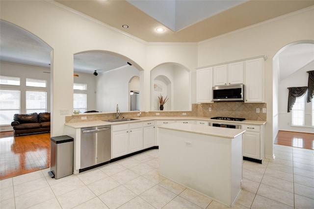 kitchen featuring stainless steel appliances, light countertops, a sink, and light tile patterned floors