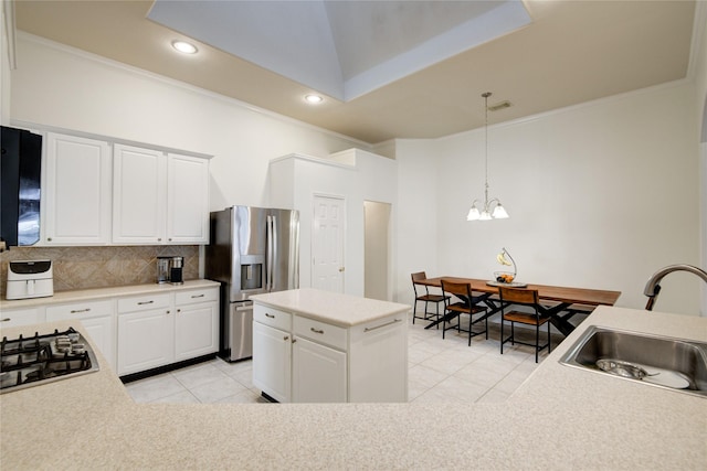 kitchen featuring light tile patterned floors, decorative backsplash, ornamental molding, stainless steel appliances, and a sink