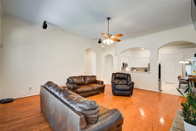 living area featuring ceiling fan with notable chandelier, wood finished floors, and crown molding