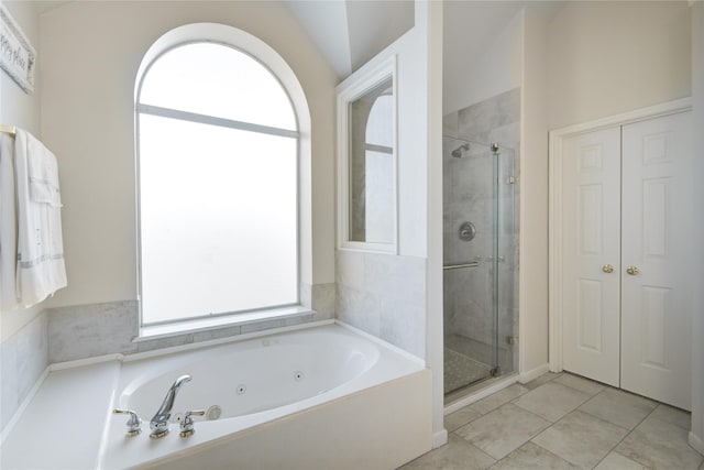 bathroom with plenty of natural light, a shower stall, and tile patterned floors