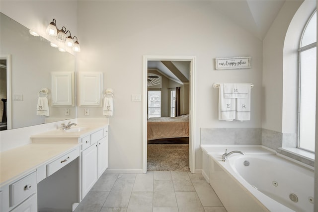 ensuite bathroom with lofted ceiling, vanity, a jetted tub, and ensuite bathroom