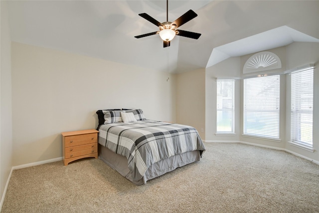 bedroom featuring lofted ceiling, light carpet, and baseboards