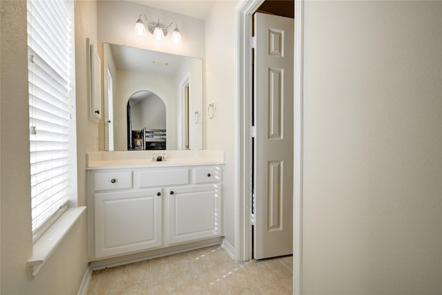 bathroom with vanity, baseboards, and tile patterned floors