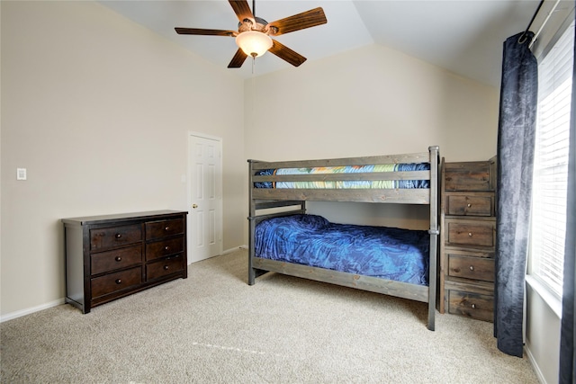 carpeted bedroom with a ceiling fan, vaulted ceiling, and baseboards