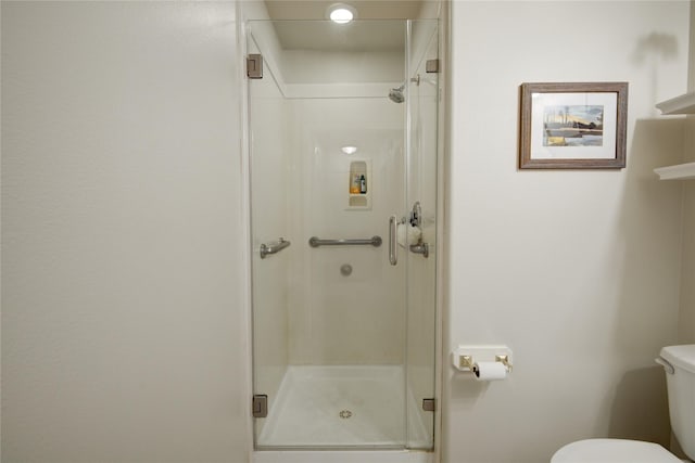 bathroom featuring a shower stall and toilet