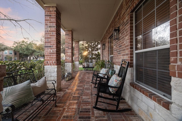 patio terrace at dusk with an outdoor hangout area and a porch