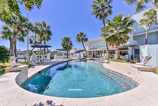 view of pool with a pool with connected hot tub and a patio