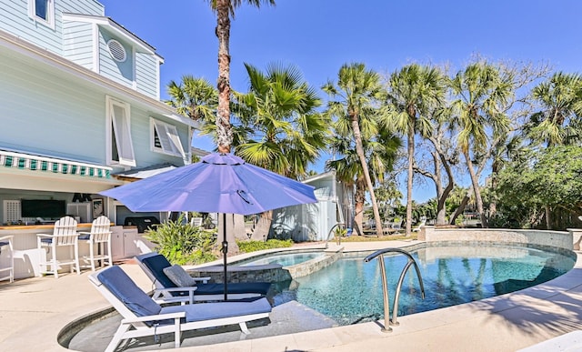 view of swimming pool with a pool with connected hot tub and a patio