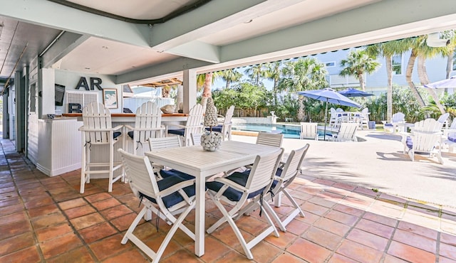 view of patio / terrace with a fenced in pool, outdoor dining area, fence, and outdoor dry bar