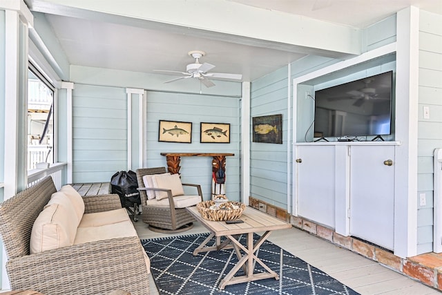 sunroom / solarium with a ceiling fan and beamed ceiling