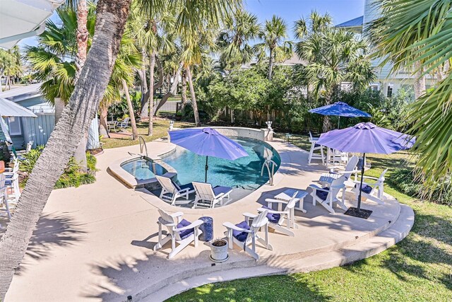 outdoor pool with fence, a patio, and an in ground hot tub