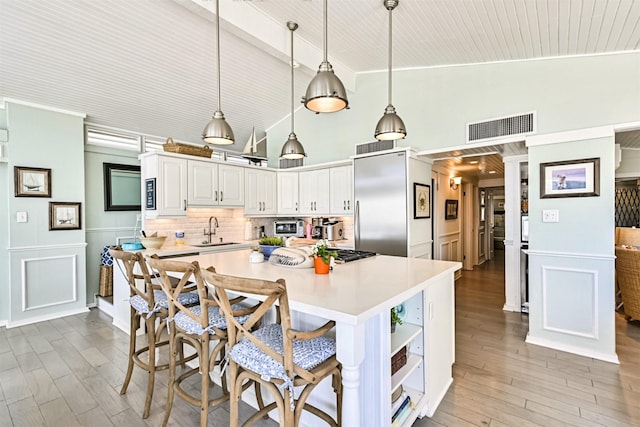 kitchen featuring high quality fridge, visible vents, light countertops, and a sink