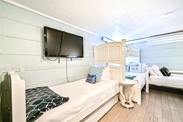 bedroom featuring a textured ceiling and wood finished floors