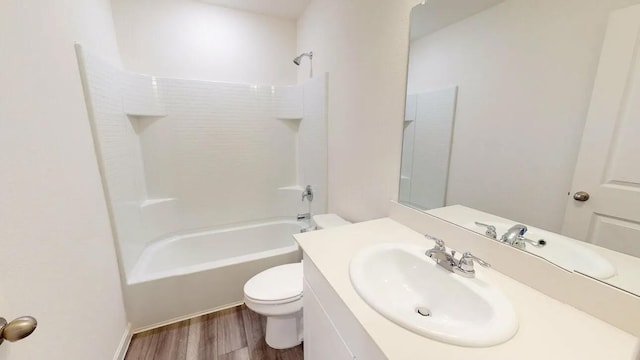 bathroom featuring toilet, shower / washtub combination, wood finished floors, and vanity