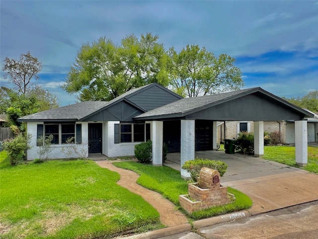 view of front of house with driveway, a garage, a front lawn, a carport, and brick siding