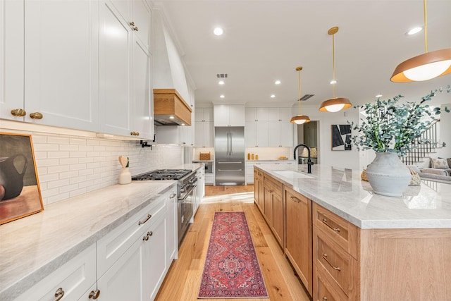 203 Munford St, Houston, TX 77008 - kitchen featuring light stone counters, light wood finished floors, a sink, high quality appliances, and backsplash