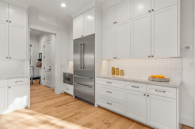 203 Munford St, Houston, TX 77008 - kitchen featuring high end fridge, light wood-style flooring, white cabinetry, backsplash, and recessed lighting
