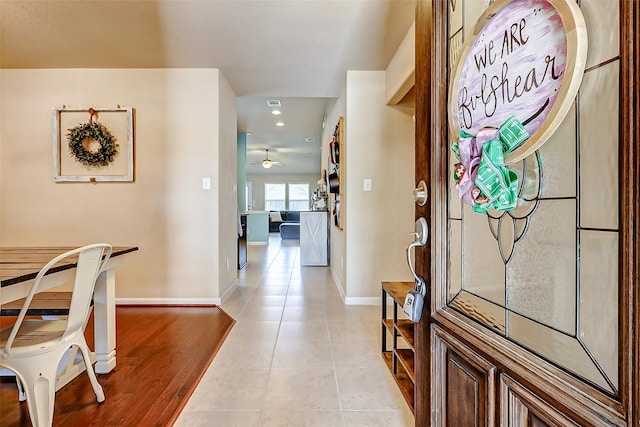 foyer entrance featuring light tile patterned flooring, visible vents, ceiling fan, and baseboards