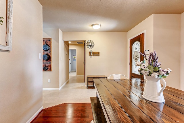 dining room with visible vents, a textured ceiling, light wood-style floors, and baseboards