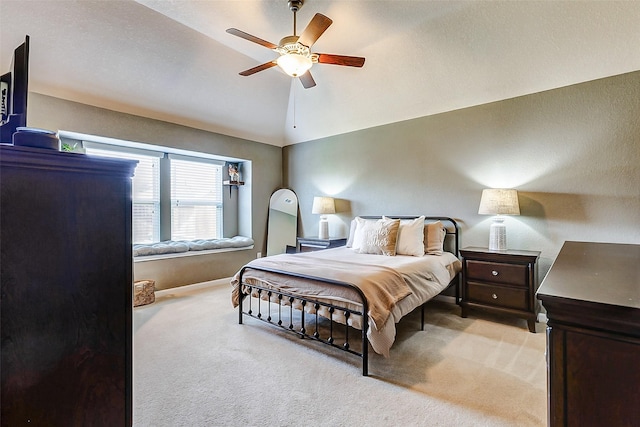 bedroom featuring light colored carpet, a ceiling fan, and lofted ceiling