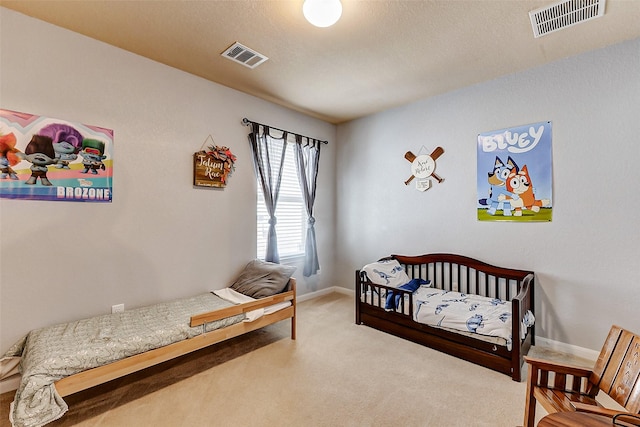 bedroom featuring visible vents, baseboards, and carpet