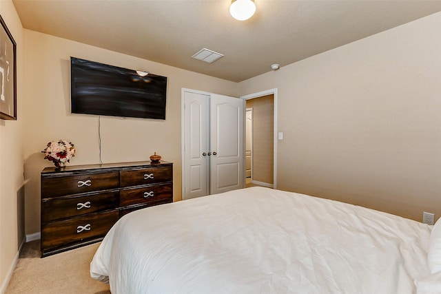 bedroom featuring visible vents, light carpet, and baseboards