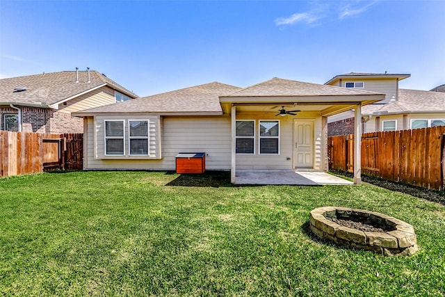 rear view of property featuring a ceiling fan, a patio, a fenced backyard, and a lawn